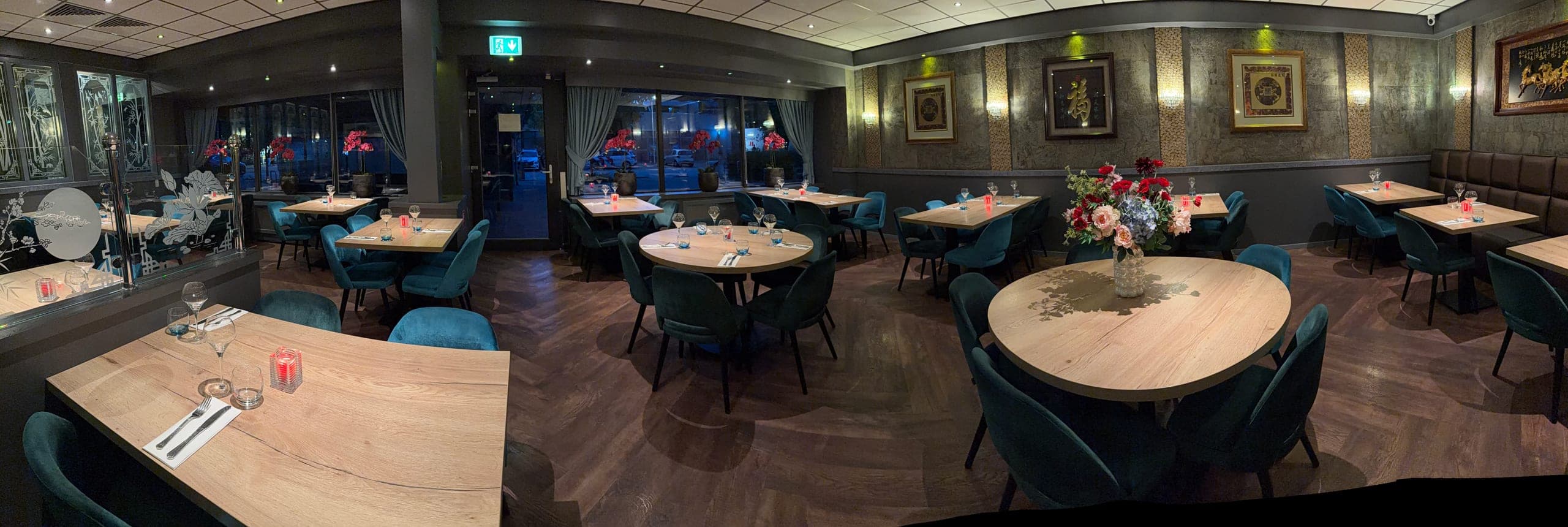 De eetzaal vanaf de andere kant, met het glazen scherm met bamboemotief en de ramen aan het plein
